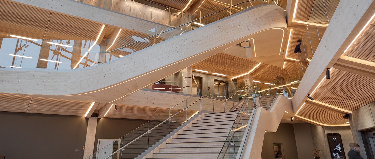 Escaleras mecánicas de acero inoxidable y vidrio dentro del edificio de oficinas desde abajo.