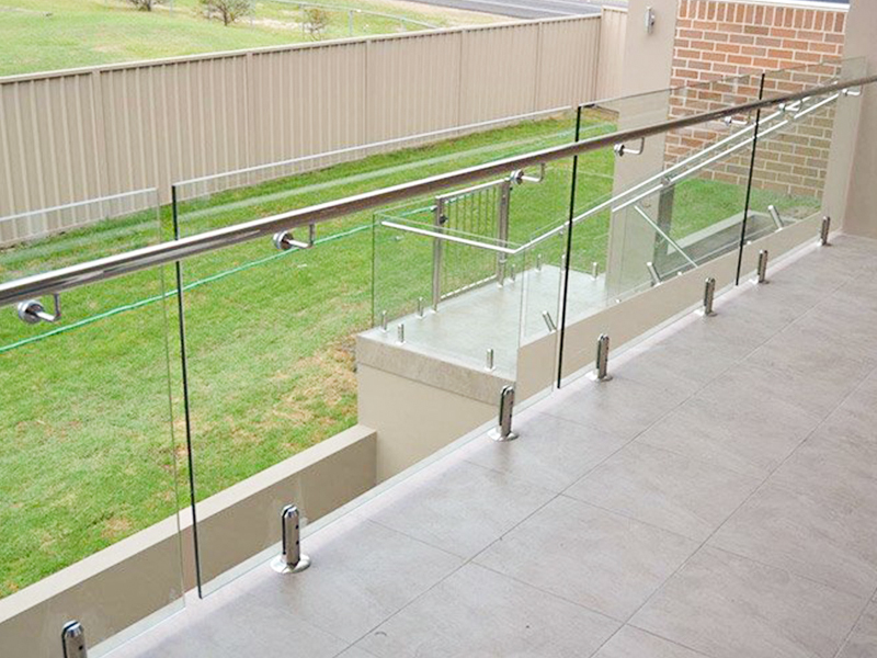 Cercas y barandillas de vidrio de acero inoxidable adornan la vista de la terraza.