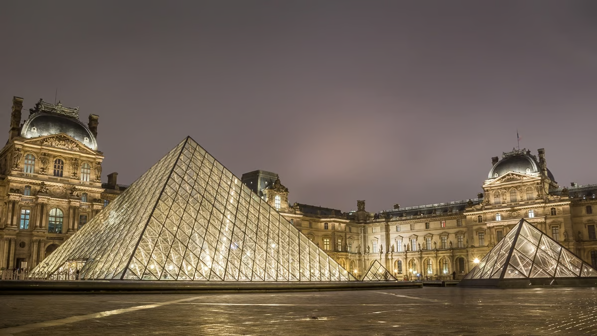 La pirámide del Louvre con estructuras de acero inoxidable por la noche.